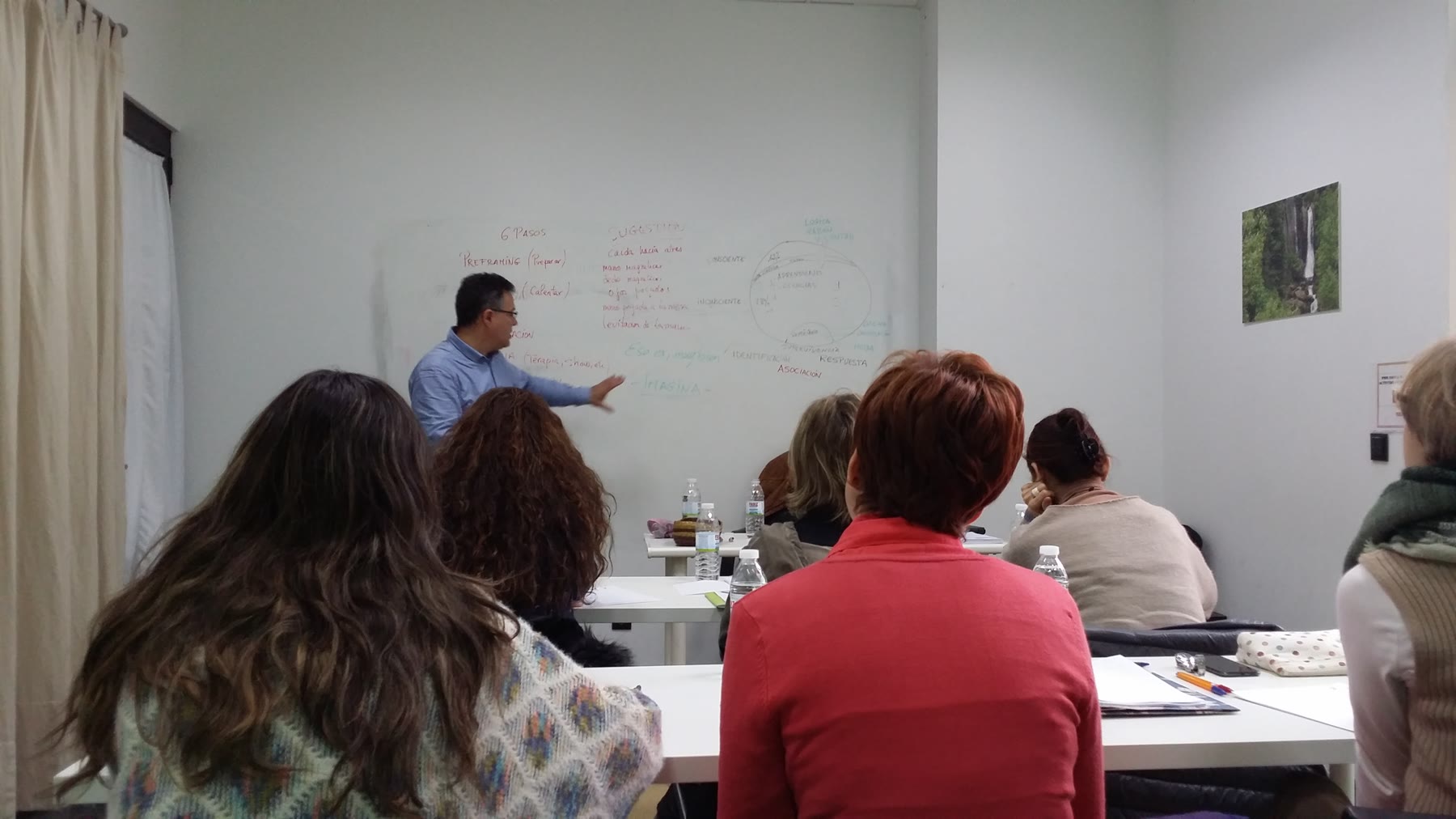 Profesor desarrolla una explicación en la pizarra ante el grupo