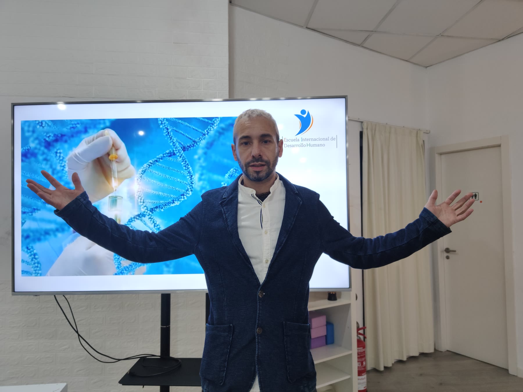 Profesor de EIDH explicando ciencia delante de una gran pantalla