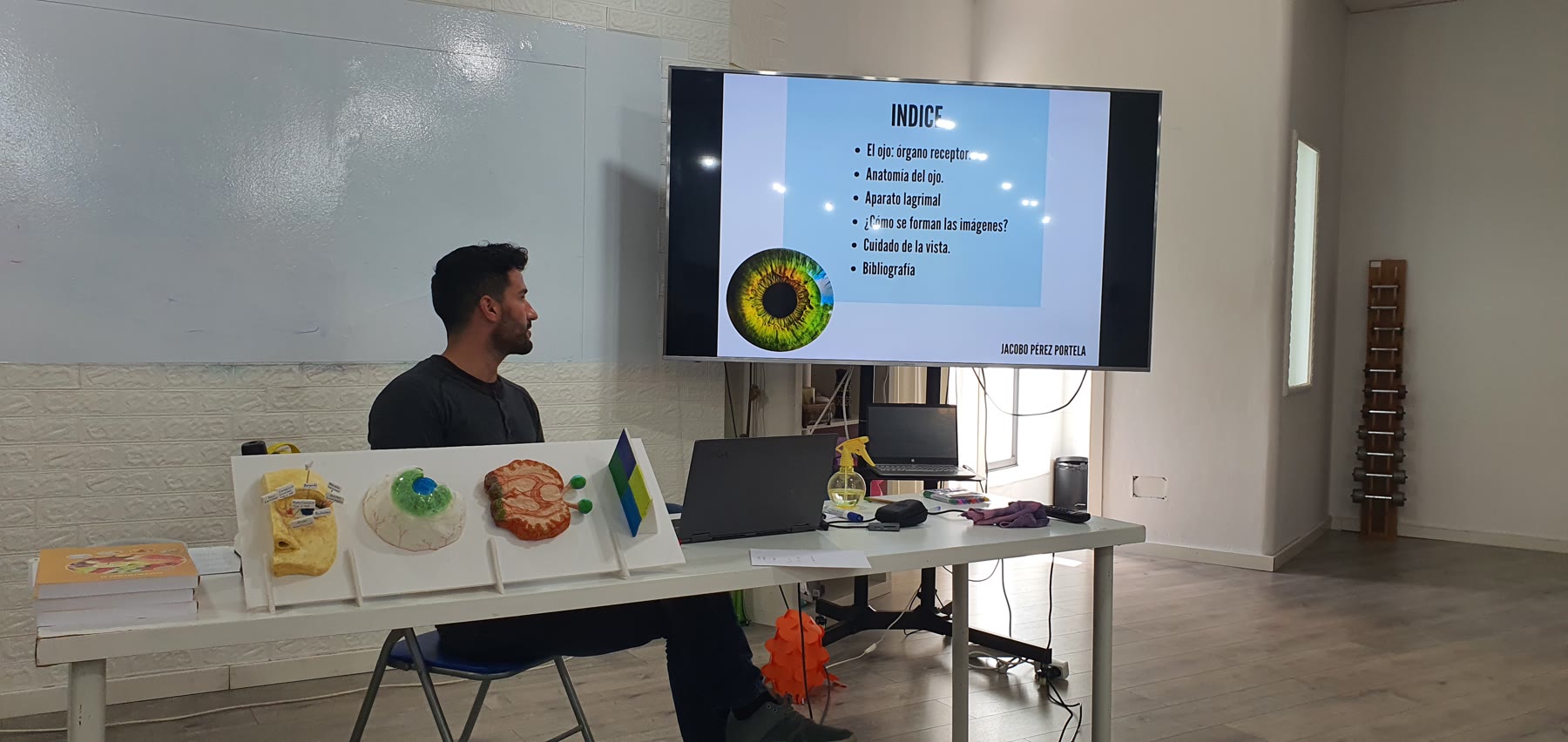 Alumno presenta un trabajo sobre el ojo con modelos y pantalla